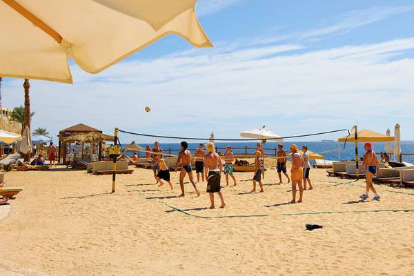 Volleyballspiel am Strand vor dem Sharm Plaza Hotel mit mehreren Spielern und Zuschauern.