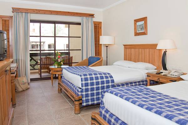 Hotelzimmer im Sharm Plaza mit zwei Betten, Tisch, Lampen und Fernseher