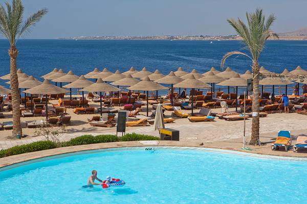 Außenbereich des Sharm Plaza Hotels mit Pool und Sonnenliegen am Strand