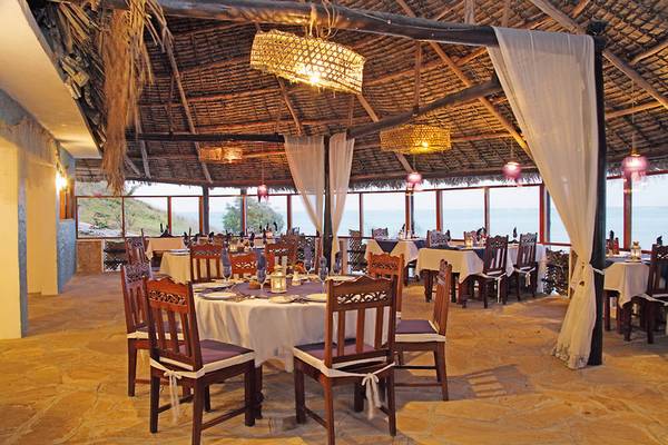 Innenansicht des Restaurants im Karafuu Beach Resort & Spa mit gedeckten Tischen und Stühlen.
