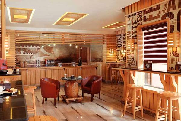 Innenansicht der Bar im Pickalbatros Alf Leila Wa Leila Resort mit Holzmöbeln, einer Theke und einer gemütlichen Sitzecke.