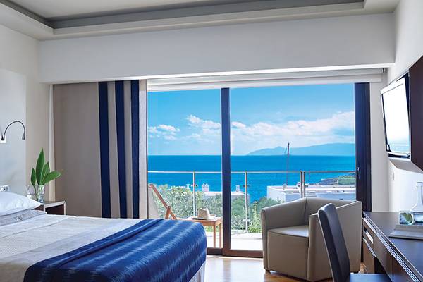 Hotelzimmer mit großem Fenster und Ausblick auf das Meer im Porto Elounda Golf & Spa Resort.