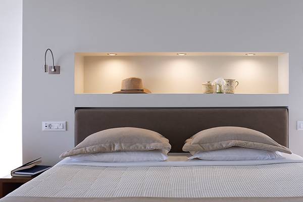 Schlafzimmer im Porto Elounda Golf & Spa Resort mit einem Bett und Kissen.