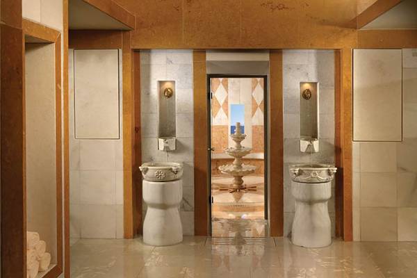 Innenbereich des Porto Elounda Golf & Spa Resorts mit weißen Marmorfliesen und Brunnen.