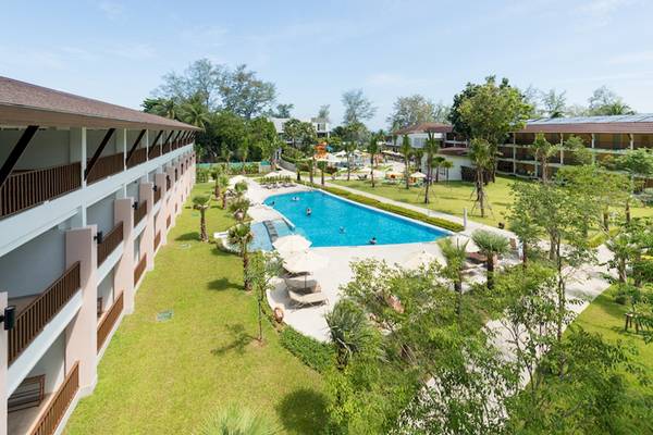 Außenansicht des Katathani Phuket Beach Resorts mit Swimmingpool und Sonnenliegen.