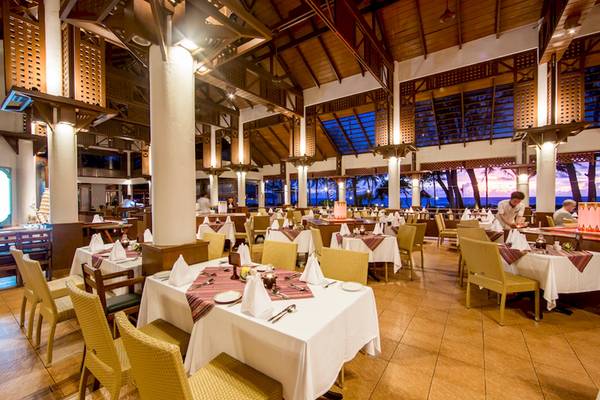 Innenansicht des Restaurants im Katathani Phuket Beach Resort mit gedeckten Tischen und Stühlen.