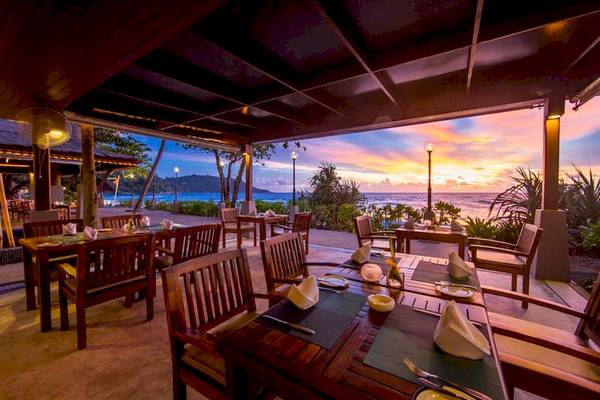 Außenbereich des Katathani Phuket Beach Resorts zum Essen mit Blick auf den Ozean und Sonnenuntergang.