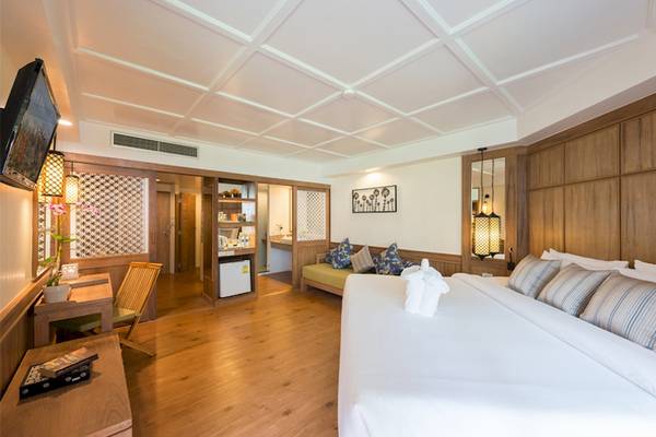 Innenansicht des Zimmers im Katathani Phuket Beach Resort mit Bett, Sofa und Schreibtisch.