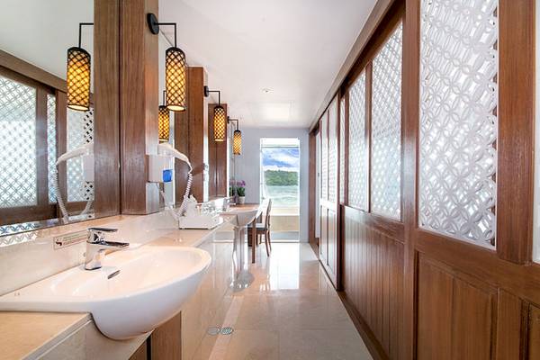 Innenansicht des Badezimmers im Katathani Phuket Beach Resort mit Waschbecken und Fenstern.