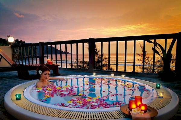 Frau im Whirlpool auf der Terrasse des Katathani Phuket Beach Resorts am Abend.