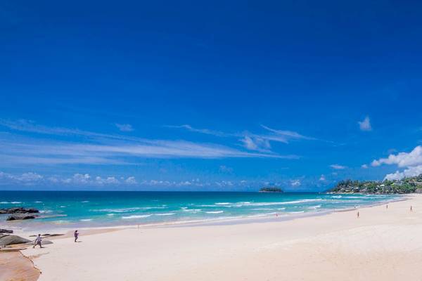 Strand des Katathani Phuket Beach Resorts mit blauem Himmel und kristallklarem Wasser