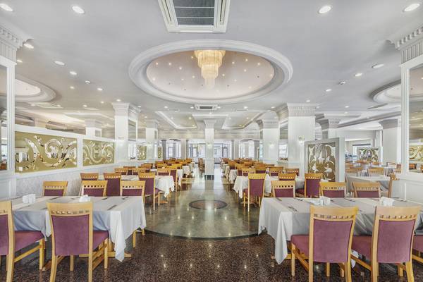 Innenbereich des Terrasse Beach Resorts mit einem eleganten Essbereich und runden Tischdecken.