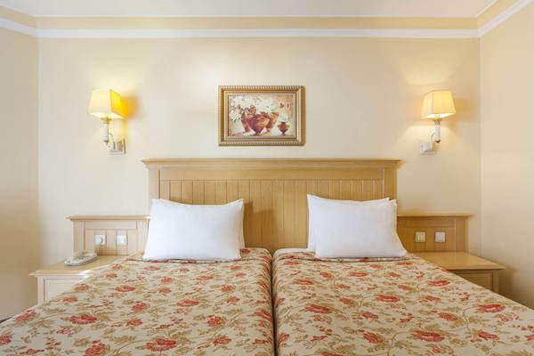 Doppelbettzimmer im Terrace Beach Resort mit floralem Bettlaken und Nachttischen