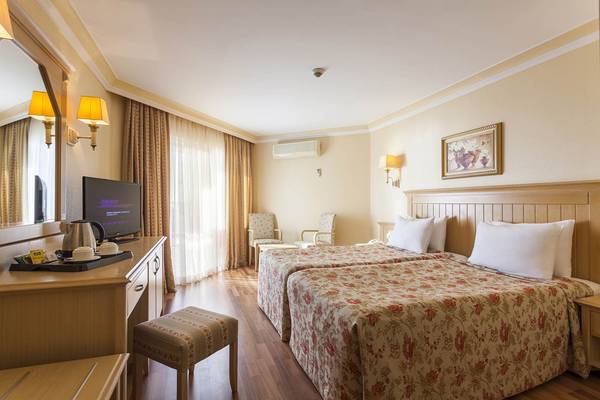 Innenansicht eines Doppelzimmers im Terrace Beach Resort mit zwei Betten, Fernseher und Möbeln.