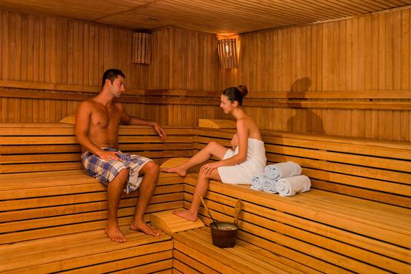 Ein Mann und eine Frau sitzen in einer Sauna im Terrace Beach Resort.