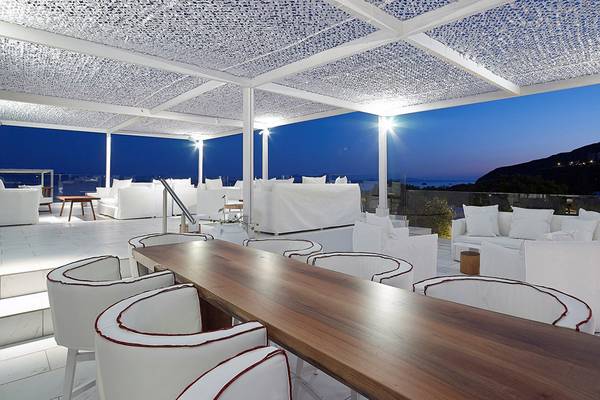 Loungebereich im Dimitra Beach Hotel & Suites mit weißen Möbeln und Deckenbeleuchtung