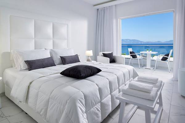 Schlafzimmer im Dimitra Beach Hotel & Suites mit Meerblick und modernen Möbeln.