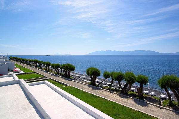 Aussicht auf das Dimitra Beach Hotel & Suites mit Blick auf den Ozean und die Berge.