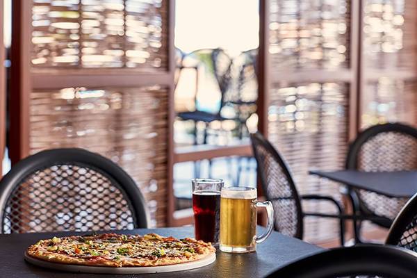 Pizza und Getränke auf einem Tisch im Restaurant des Atlantica Mikri Poli Kos.