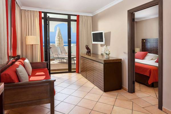 Suite-Zimmer im Seaside Sandy Beach Hotel mit Blick auf das Meer und einen Balkon.