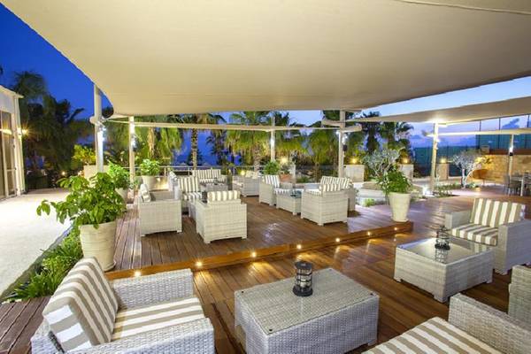 Lounge-Bereich des Aquamare Beach Hotel & Spa mit abendlicher Beleuchtung und Möbeln.