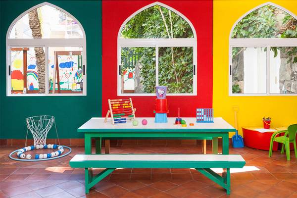 Kinderzimmer im Seaside Sandy Beach Hotel mit bunten Wänden, bunten Spielsachen und einem Tisch.