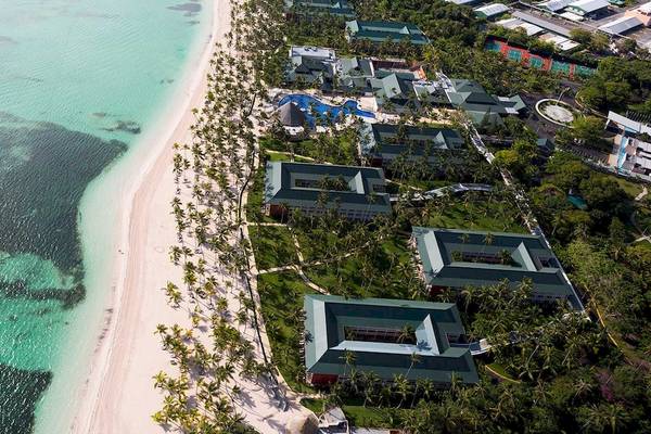 Luftaufnahme des Barcelo Bavaro Strand Hotels mit weißen Sand, türkisfarbenem Wasser und grünen Gebäuden