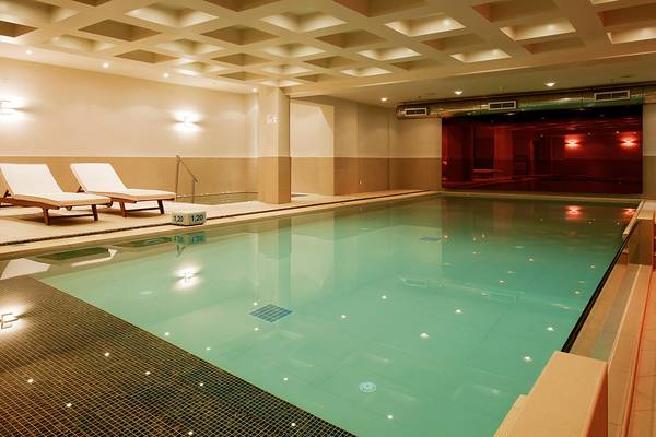 Innenpool im Pearle Beach Resort & Spa mit zwei Liegen und türkisfarbenem Wasser.