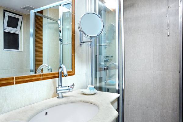 Badezimmer mit Spiegel und Dusche im Pearle Beach Resort & Spa.