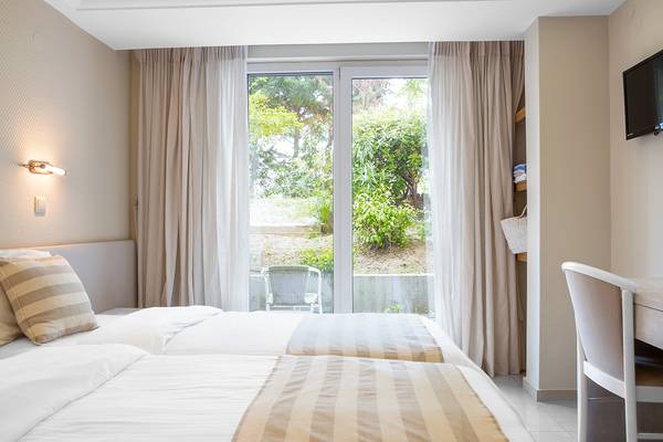 Zwei Betten mit Aussicht auf Garten im Zimmer des Pearle Beach Resort & Spa