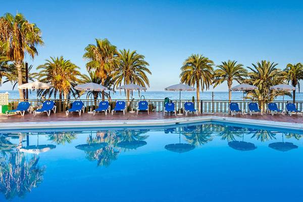 Außenpool des Sol Tenerife Hotels mit Sonnenliegen und Palmen am Rand.