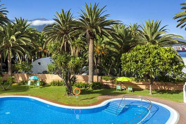 Außenansicht des Swimmingpools des Sol Tenerife Hotels, umgeben von Palmen und Grün.