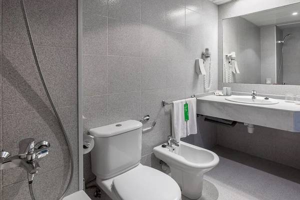 Ein Badezimmer im Sol Tenerife Hotel mit einer Dusche, Toilette, Bidet und Waschbecken.