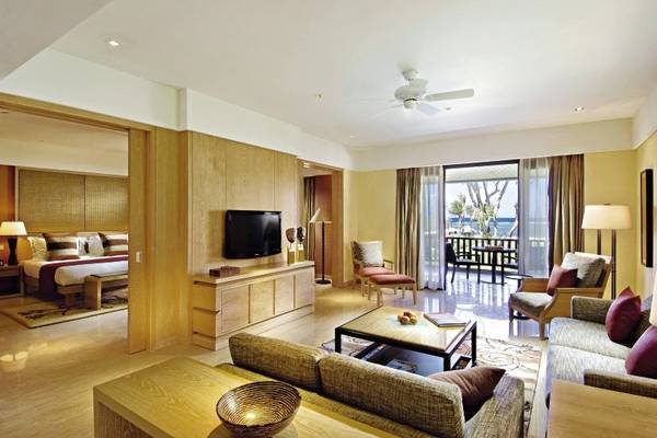 Innenansicht einer Suite im Conrad Bali Resort & Spa mit Wohnbereich, Schlafbereich und Terrasse.