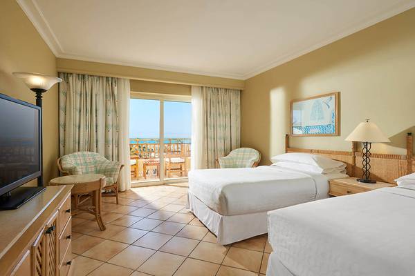 Doppelzimmer mit Meerblick im Sheraton Soma Bay Resort mit zwei Betten, Fernseher, Tisch und Balkon