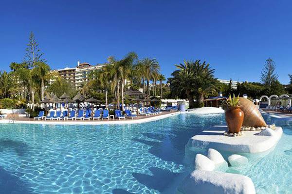 Außenpool des Paradisus by Melia Gran Canaria Hotels mit Lounge-Stühlen und Palmen.