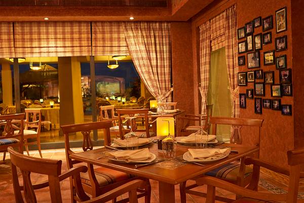 Innenbereich des Sheraton Soma Bay Resorts, Restaurantbereich mit Tisch, Stühlen, Kerzen und Tischdekoration.