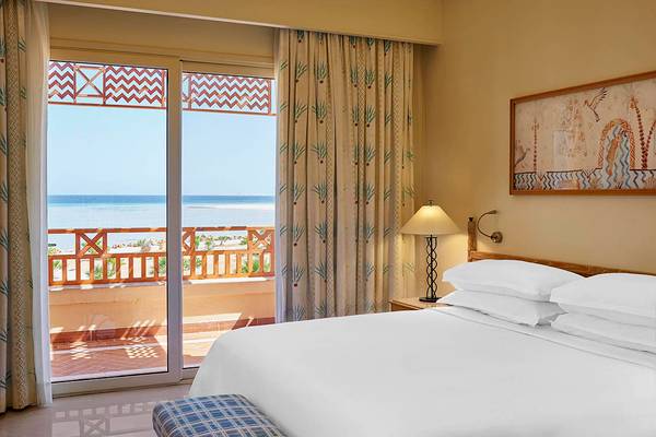 Bettzimmer im Sheraton Soma Bay Resort mit Meerblick, großen Fenstern und Dekor.