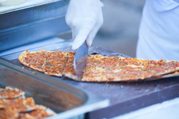 Eine Person schneidet eine Pizza im Washington Resort Hotel & SPA.
