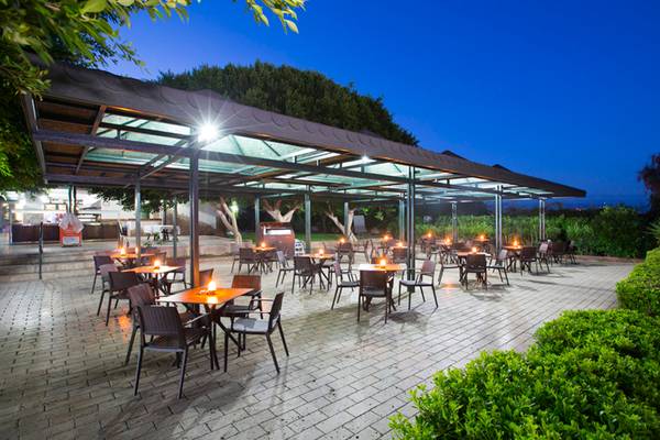 Außenbereich des Washington Resort Hotel & SPA bei Nacht mit beleuchteten Tischen und Stühlen.