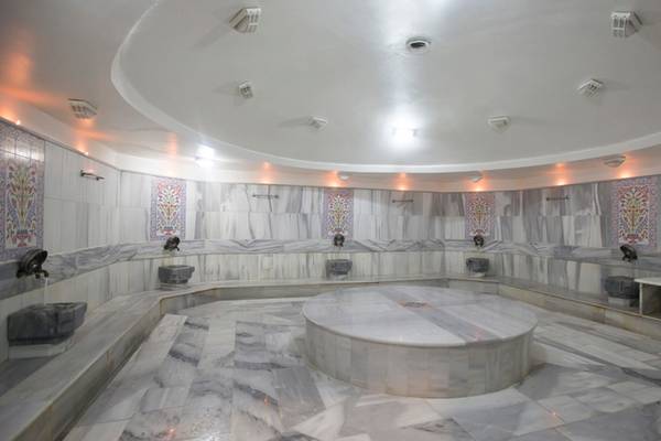 Innenbereich der Sauna im Washington Resort Hotel & SPA mit Marmorboden und weißen Wänden.