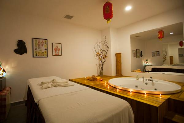 Behandlungsraum im Washington Resort Hotel & SPA mit zwei Massagetischen, einer Badewanne und dekorativen Elementen.