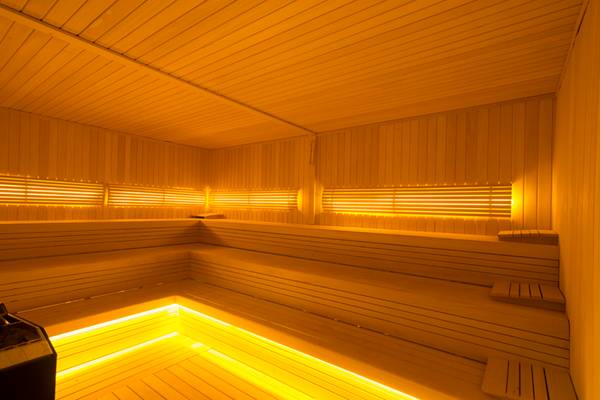 Sauna im Washington Resort Hotel & SPA mit warmem, gelbem Licht und Holzwänden.
