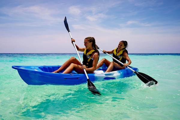 Zwei Frauen paddeln in einem blauen Kajak im Fushifaru Maldives.
