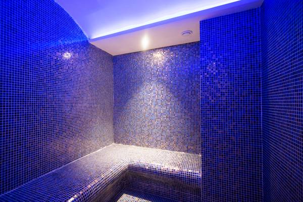 Innenbereich der Sauna im Washington Resort Hotel & SPA mit blauen Fliesen und Beleuchtung.