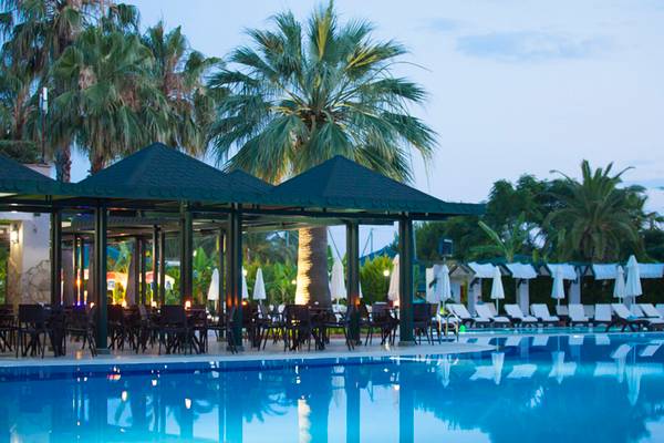 Pool-Terrasse im Washington Resort Hotel & SPA mit Tischen und Stühlen unter Pavillons.