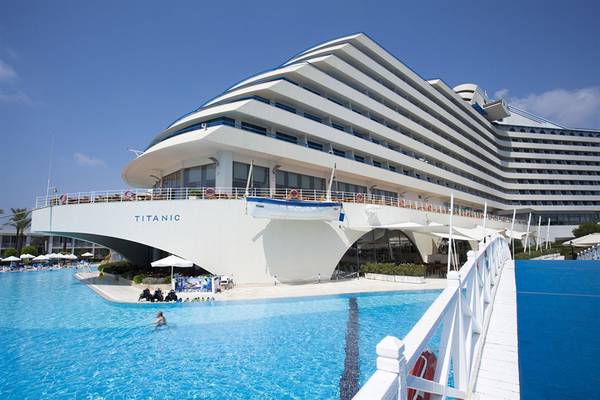 Außenansicht des Titanic Deluxe Lara Hotels mit großem Pool und moderner Architektur.