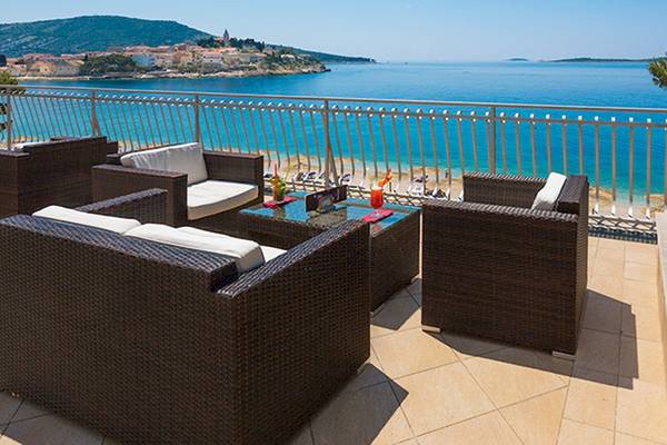 Zora Hotel Terrasse mit Blick auf das Meer und eine Sonnenuntergangszene.