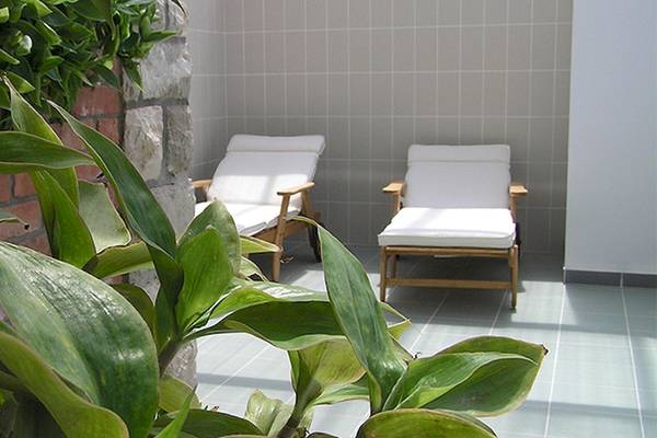 Lounge-Bereich im Zora Hotel mit zwei weißen Sofas und Pflanzen