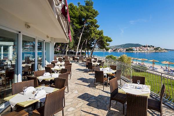 Außenterrasse des Zora Hotels mit Blick auf das Meer und den Strand.